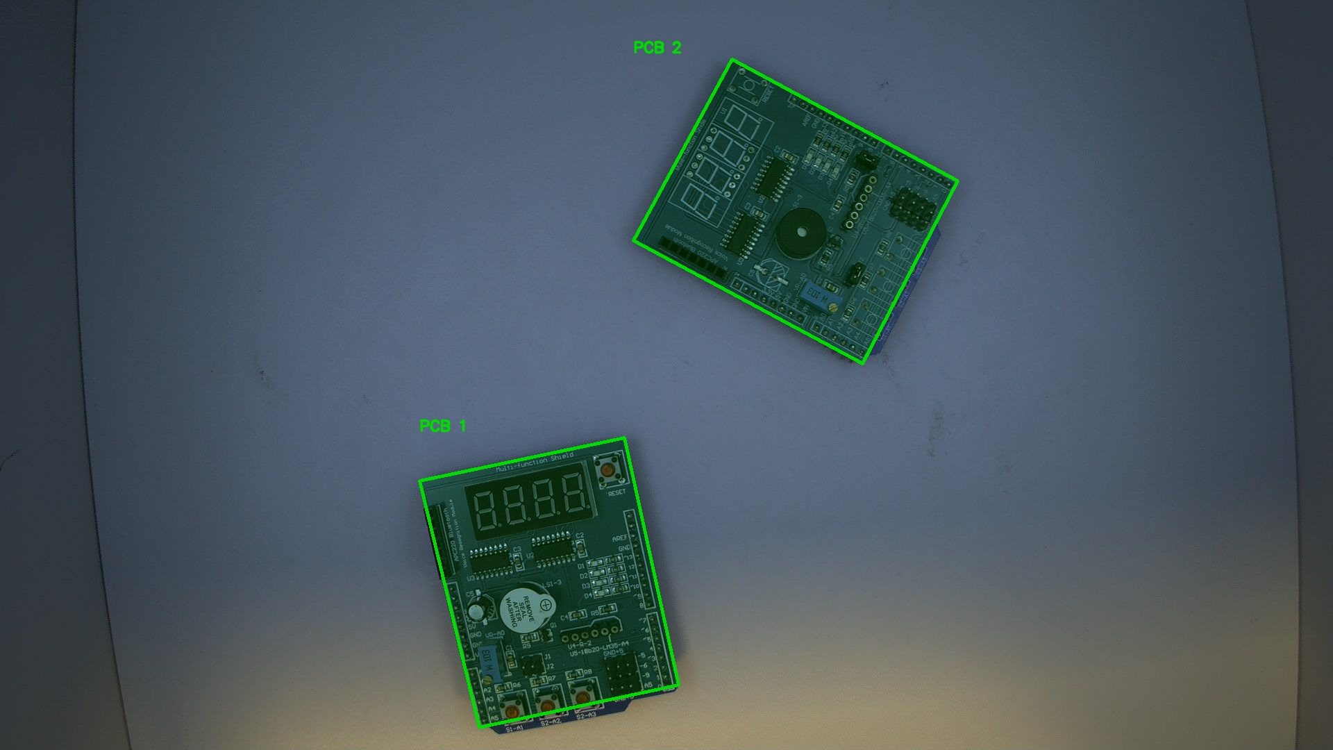 Input image with two PCB detections highlighted by green polygons